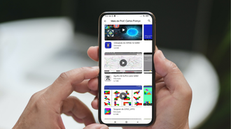 Imagem de duas mãos segurando um smartphone no qual aparecem três aplicativos publicados pelo grupo coordenado pelo professor Carlos França