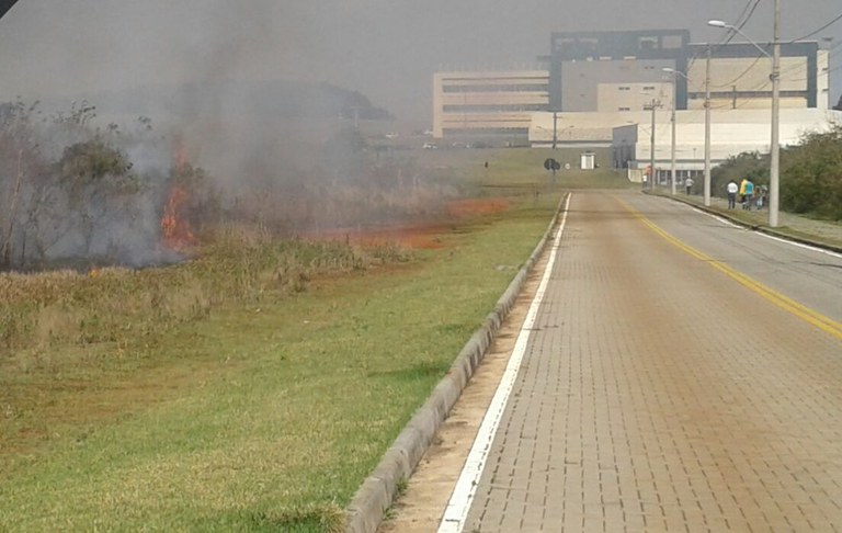 Chamas e fumaça em primeiro plano com o prédio da biblioteca da UFFS - Campus Chapecó ao fundo