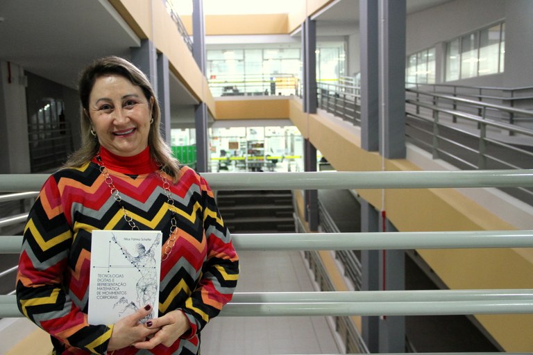 Professora Nilce segura o livro recém lançado