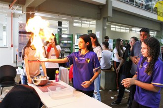 Na foto uma estudante demonstra o experimento durante as atividades da V Feira de Ciências, realizada em 2023.