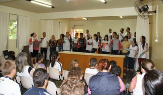 Na foto os integrantes do projeto estão em frente ao público fazendo apresentação. Eles seguram em suas mãos instrumentos musicais.