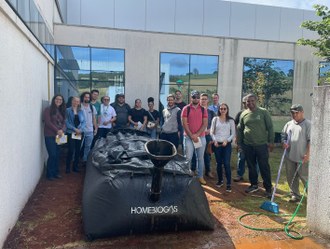 Na imagem um grupo de pessoas posa para foto junto ao biodigestor.