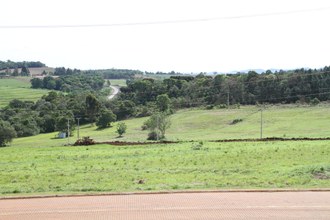 Na imagem em plano aberto, uma máquina está fazendo terraplanagem em terreno onde será instalada a Estação de Aquicultura.