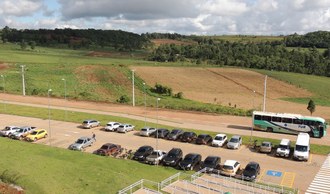 Na imagem um estacionamento com diversos carros.