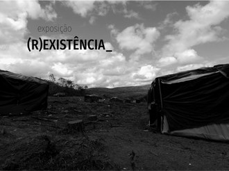 Foto em plano aberto da comunidade quilombola. Ao lado direito, em preto e branco, um barraco de lonas pretas. Acima e à esquerda, o texto: "exposição (r) existência"